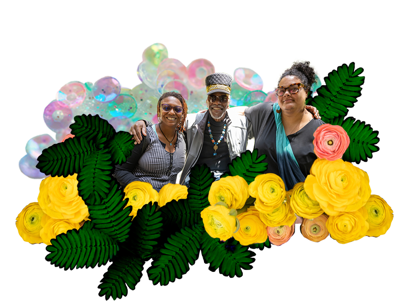 Team Unicorn members Raychelle Heath and Katherine Agard seated next to Watani Stiner, a member of the Bolt Cutters Cohort. The foreground has yellow flowers and ferns, with rainbow-colored sequins in the background.